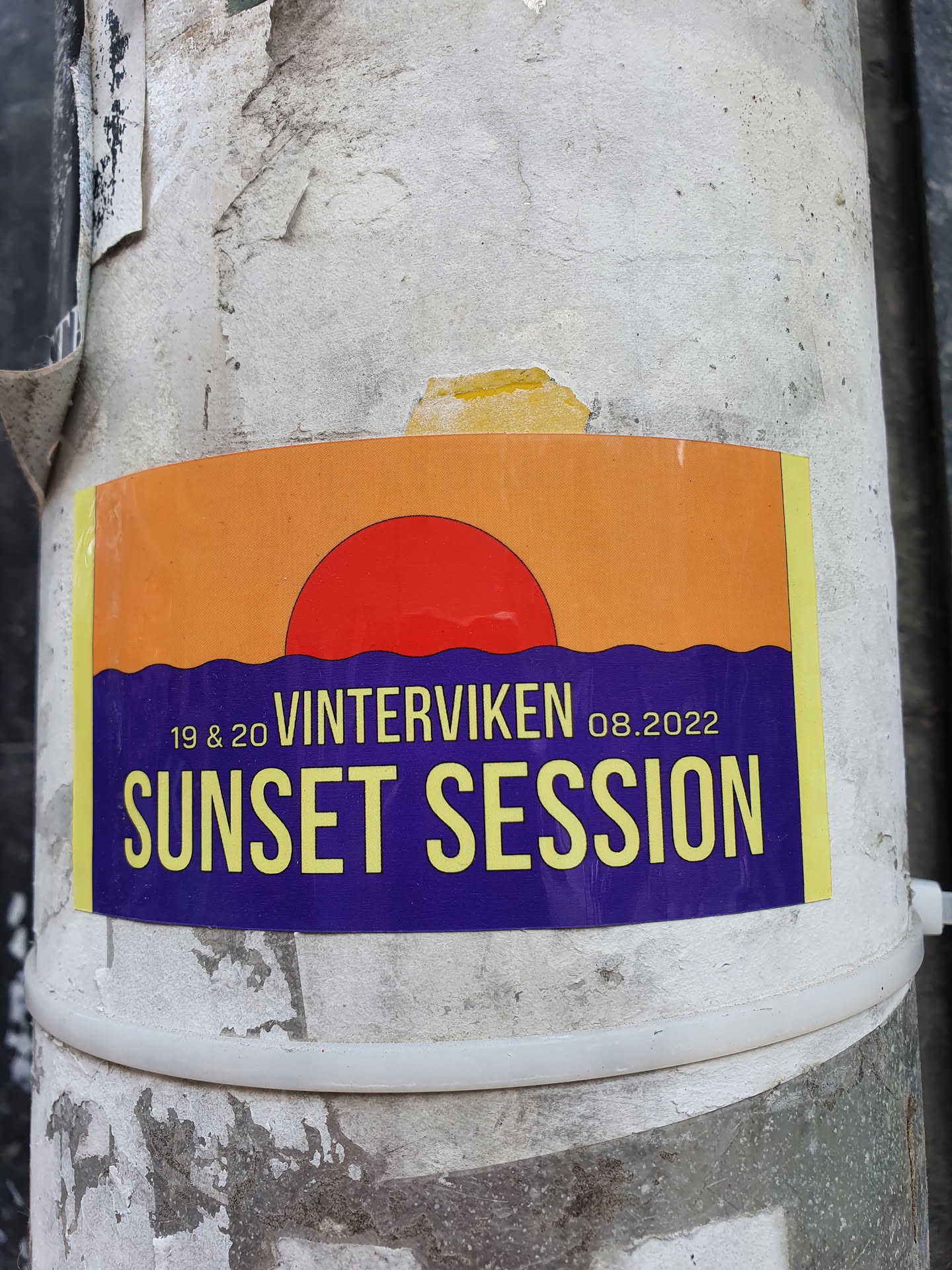A sticker advertising a sunset session event at Vinterviken on August 19th and 20th, 2022. The sticker features a graphic of a red sun setting over water.
