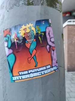 A sticker with a vibrant illustration of stylized figures in a futuristic setting. The main focus is two figures embracing, while other figures are dancing in the background. The sticker has a bold text at the bottom stating "The Future is Intersectional".