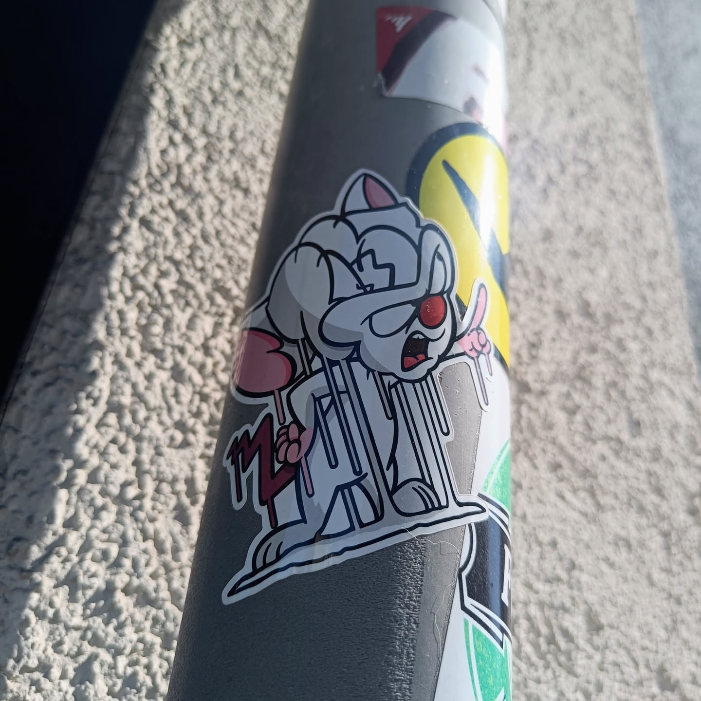 A vinyl sticker featuring a stylized illustration of Pinky from the cartoon series Pinky and the Brain.  Pinky is depicted in a doctor's outfit, appearing slightly deranged and holding a lollipop. The art style is clean and modern with a focus on bold lines.