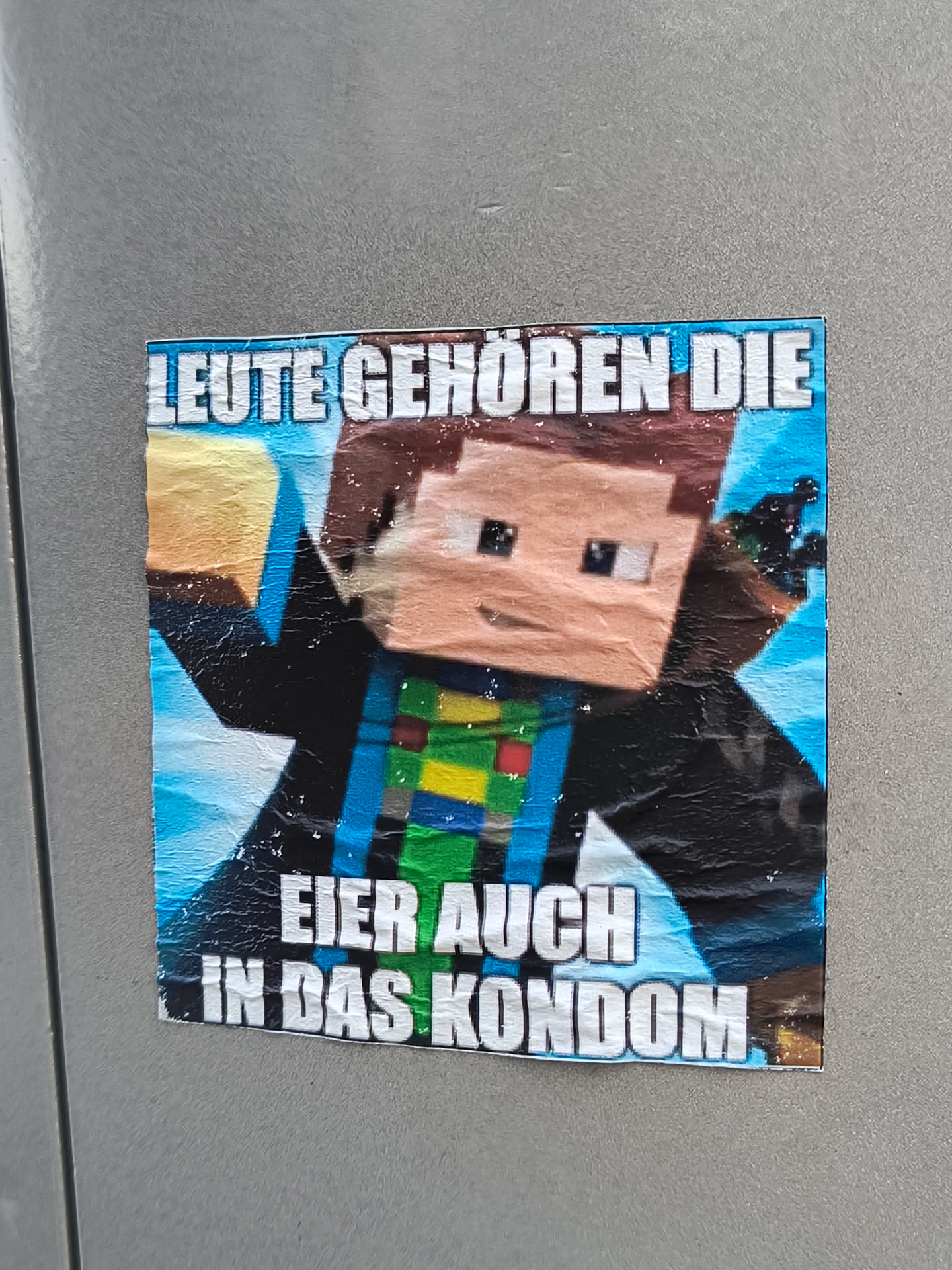 A sticker featuring a Minecraft character and a German meme-like phrase. The text translates to something like: "People belong the eggs also in the condom."