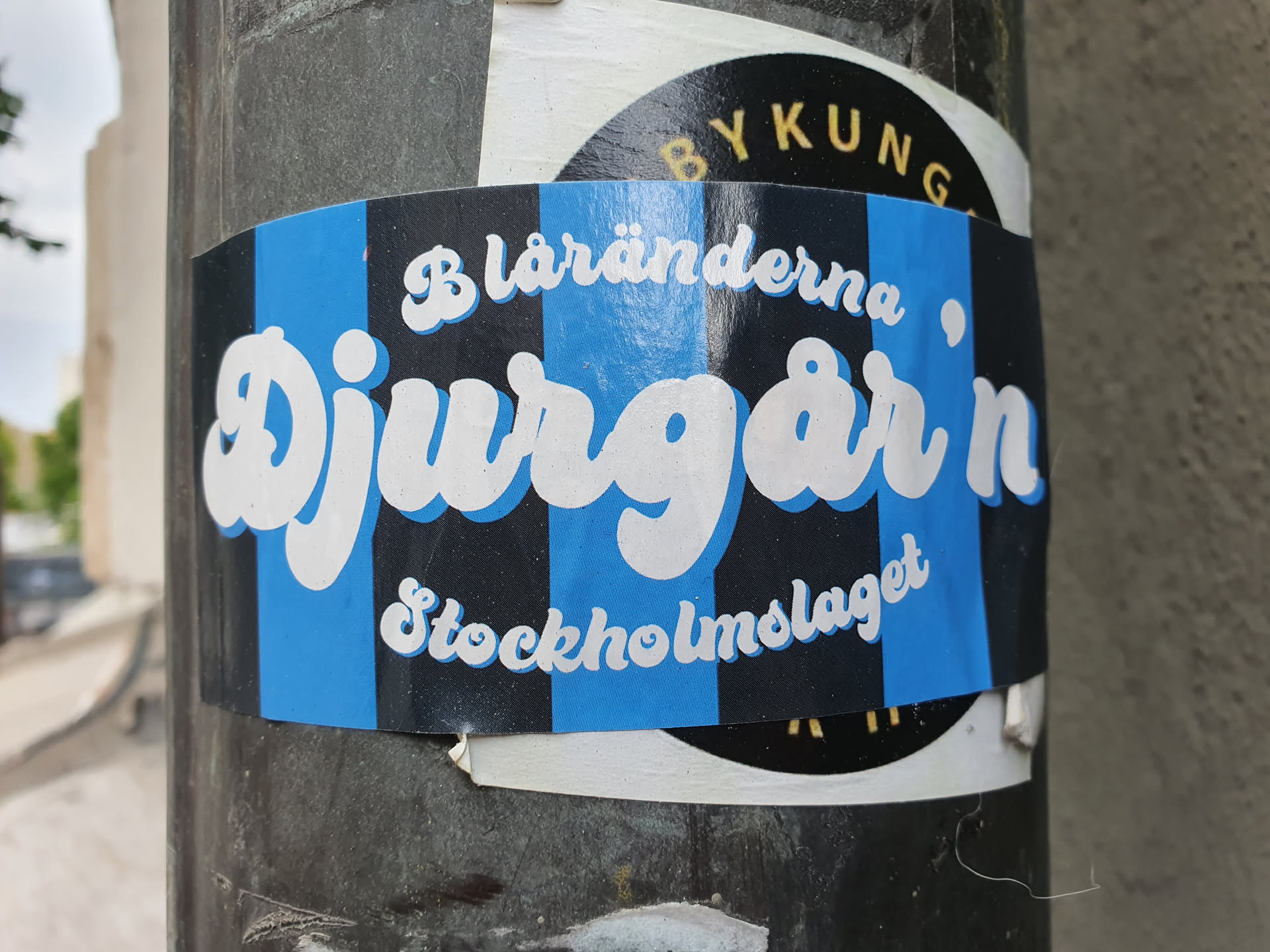 A blue and black striped sticker with the words "Djurgården" in a stylized white font. Smaller text above and below reads "Blåränderna" and "Stockholmslaget".