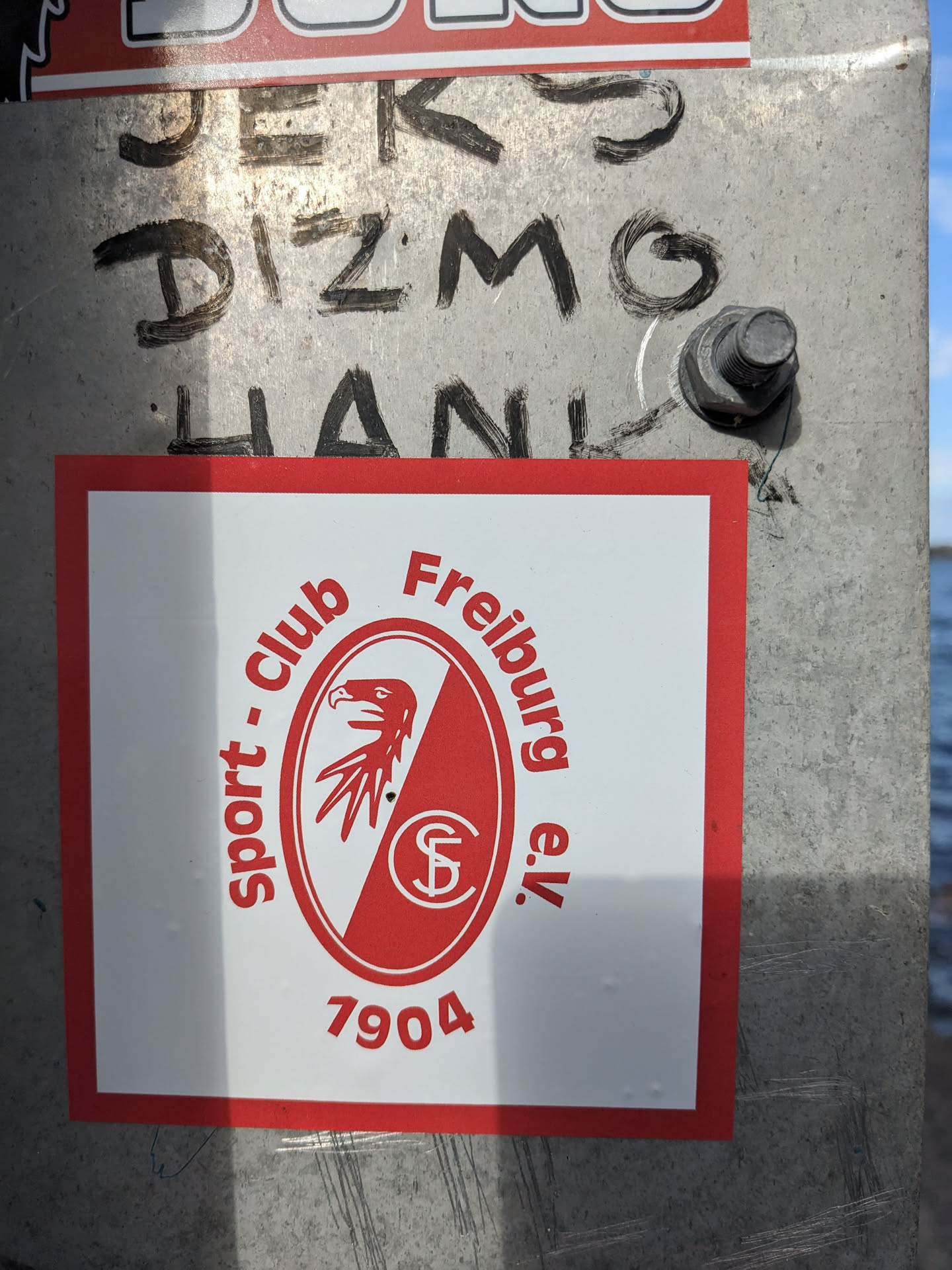 A sticker featuring the logo of SC Freiburg Sport Club, a German football team. The logo shows a red oval with an eagle and the club's initials. The number 7904 is printed below the logo. The sticker is rectangular with a red border and a white background.
