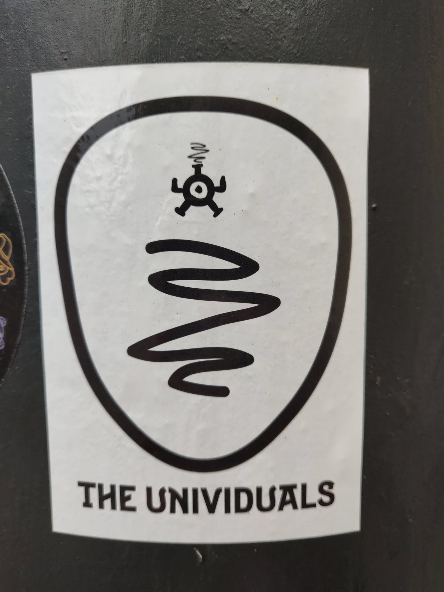 Black and white sticker with a unique design. It features a stylized figure with a spiral and the words "THE UNIVIDUALS" at the bottom.