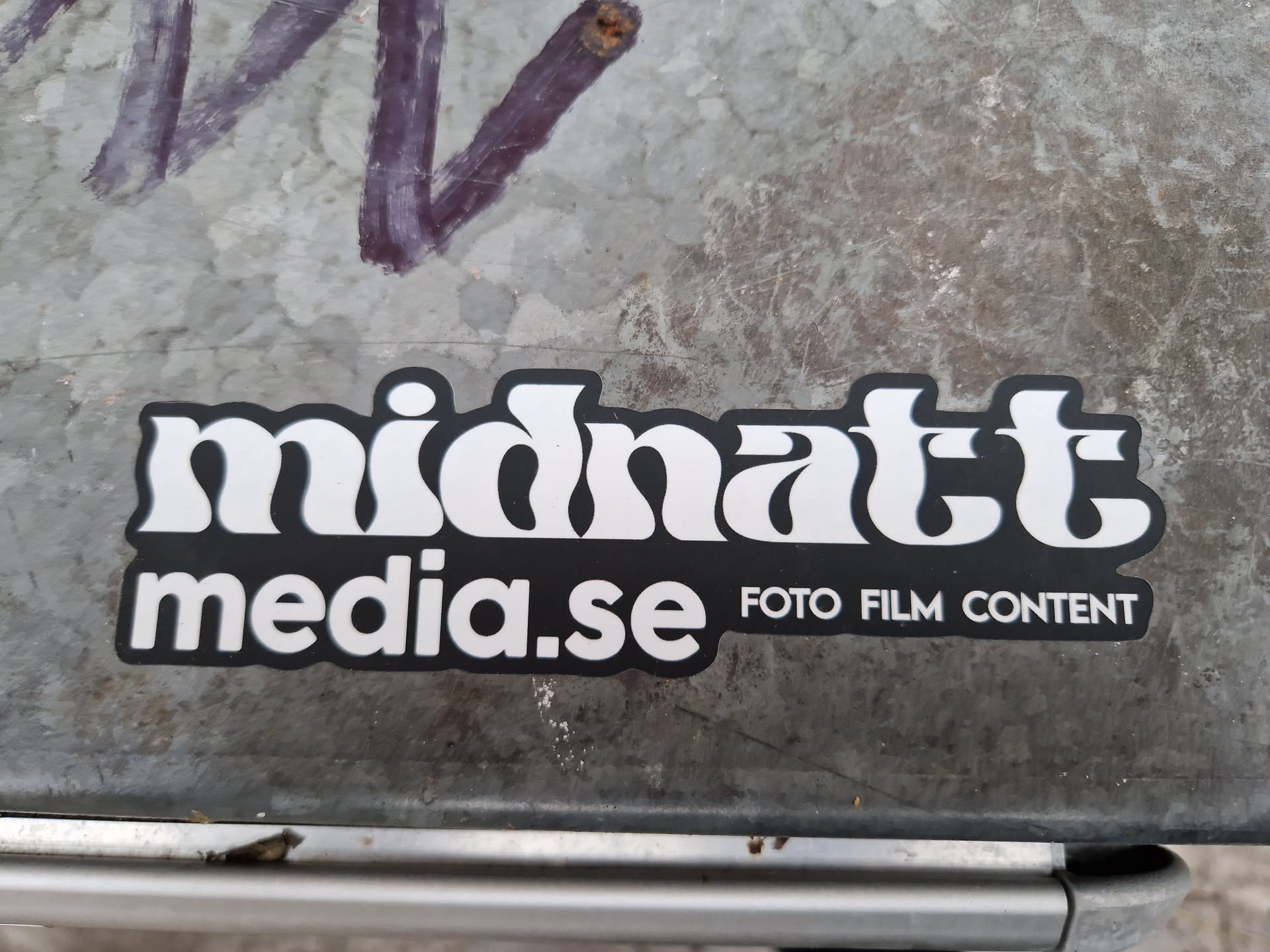 Black and white sticker with the text Midnatt media.se and the words Foto Film Content underneath. The text Midnatt uses a stylized font.