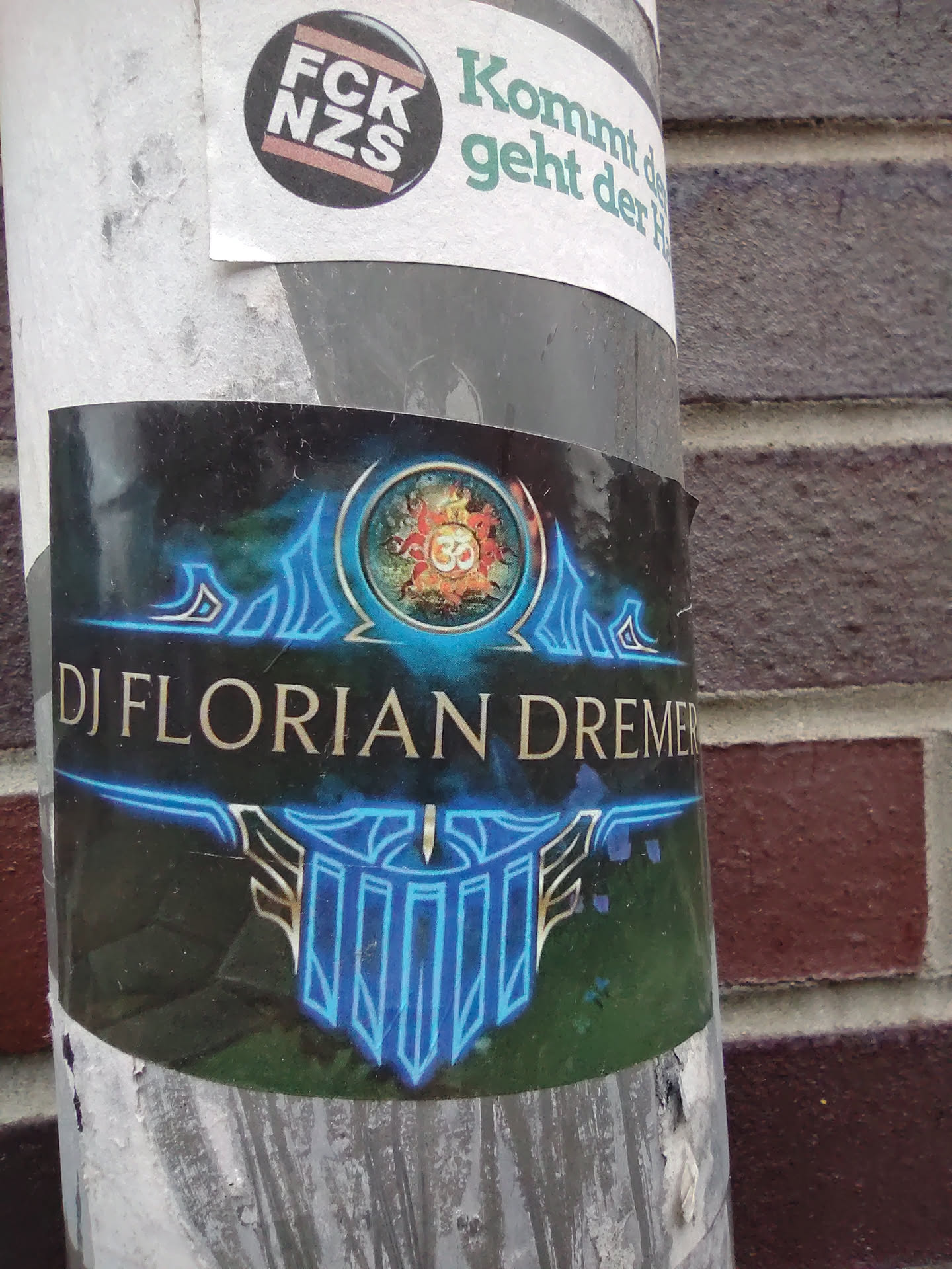 A sticker featuring the name "DJ Florian Dremer" in gold lettering on a dark background.  A blue and gold design with what appears to be a stylized Om symbol is featured prominently. The overall aesthetic is mystical and electronic music-themed.