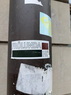 A simple yet striking sticker featuring the name "Frölunda HC" in a minimalist design. The color scheme is mainly dark green and maroon, with white text providing a clear contrast. It's likely representing a hockey club or team.