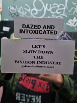 A sticker with a message advocating for slowing down the fashion industry.  It's from the brand Dazed and Intoxicated.