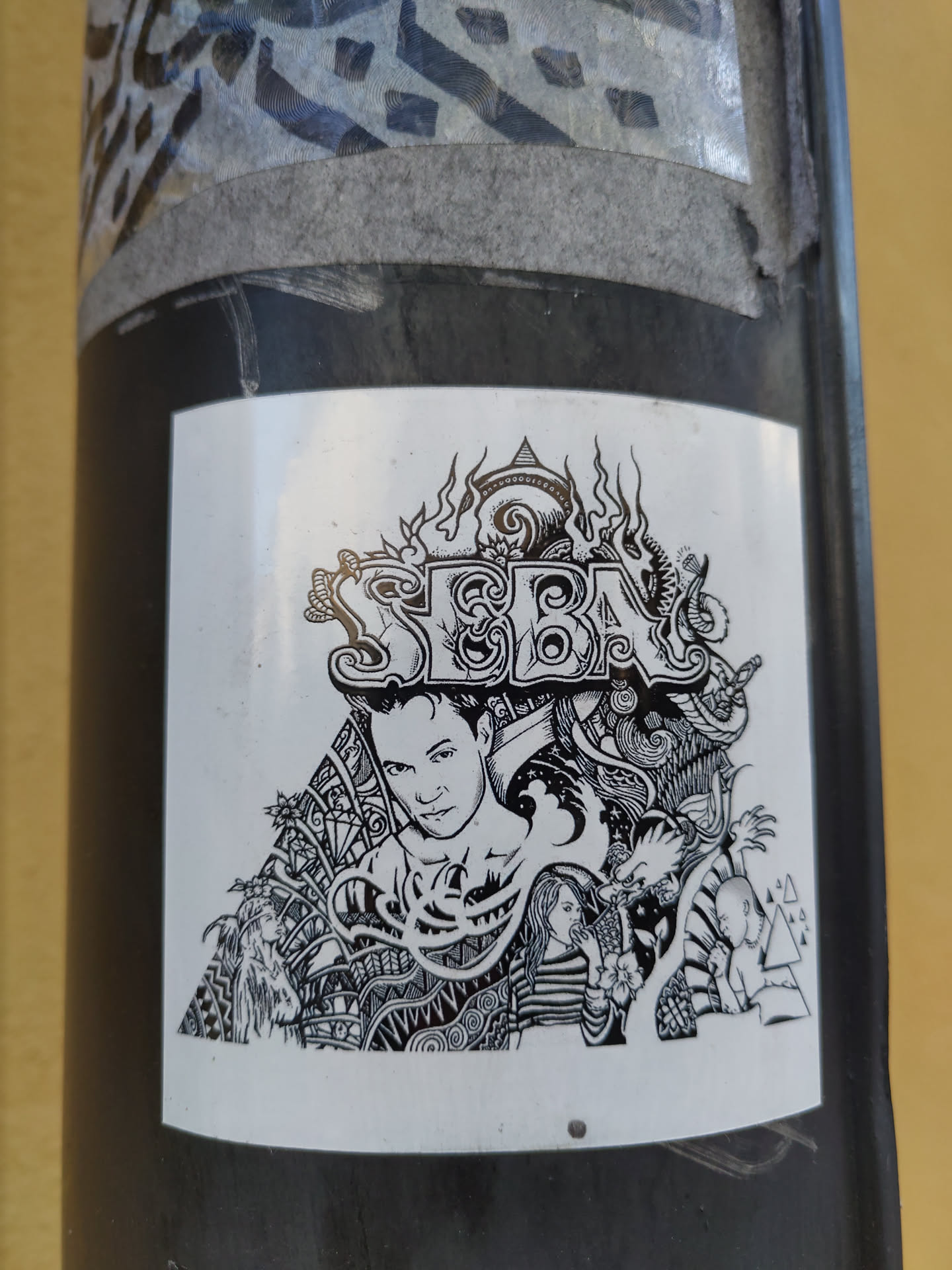 A black and white sticker with the prominent name 'SEBA' in stylized lettering. The design incorporates detailed line art, including a central portrait of a person, possibly the artist or a subject.  The style is reminiscent of zentangle or similar intricate illustrative techniques.  Surrounding the main portrait are additional elements that appear to be part of an overall cohesive design.