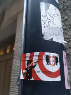 Street sticker A sticker featuring a cartoon of a man throwing a dart at a target with the Portuguese coat of arms. The text on the sticker says "Nosso Destino é o de Vencer", which translates to "Our destiny is to win."