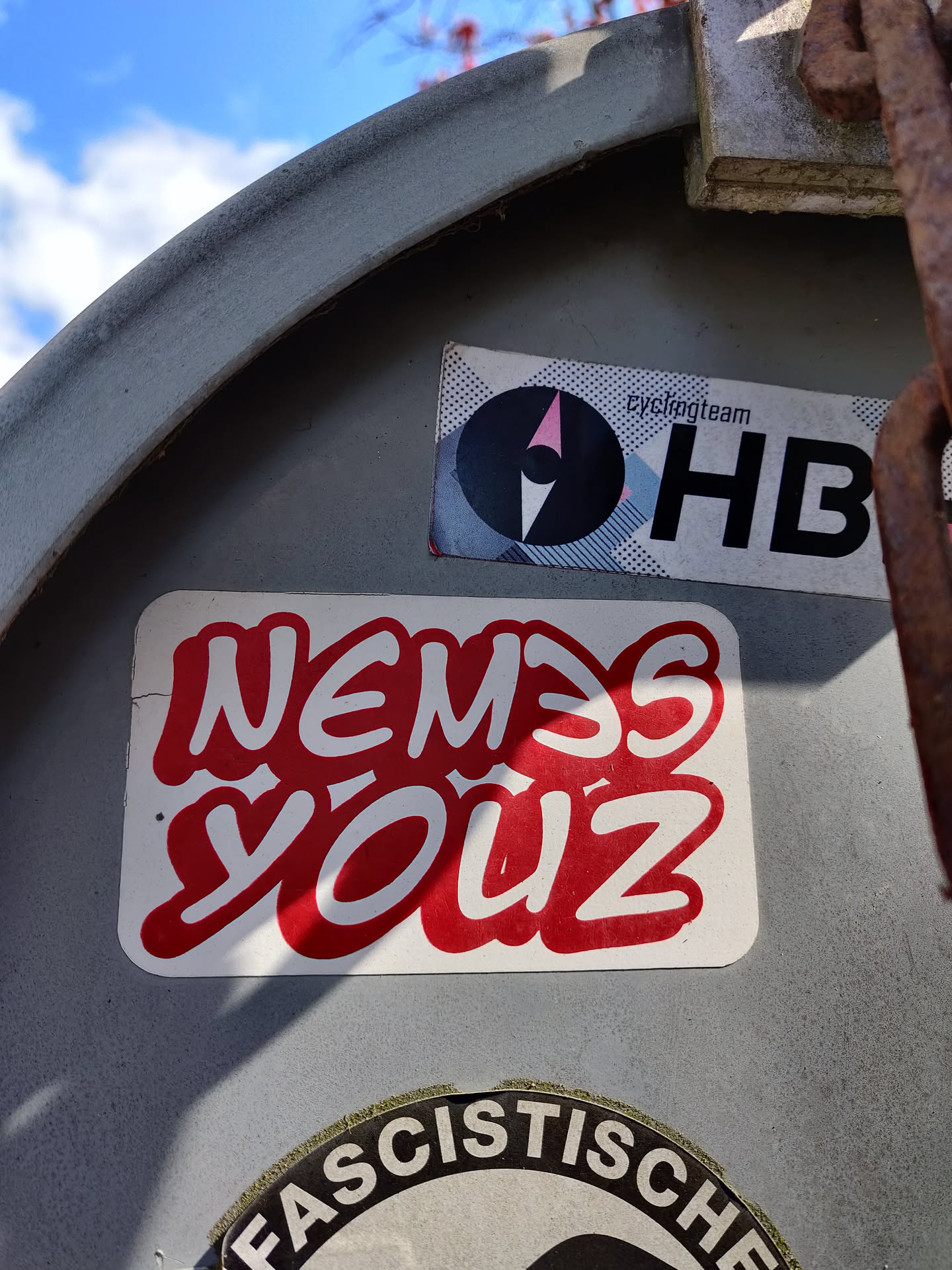 A red and white sticker with graffiti-style lettering that says "Nemesis Youz".