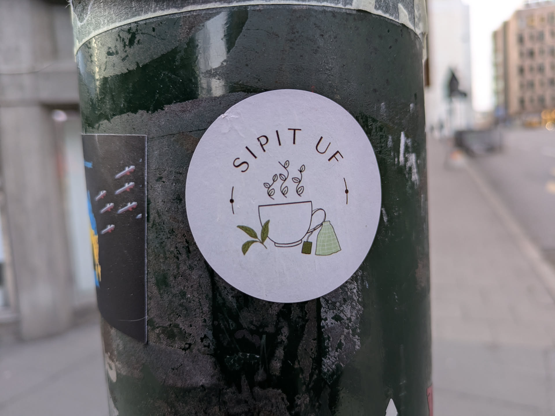A round sticker featuring a minimalist illustration of a cup of tea with tea bags and leaves. The text 'SIP IT UP' is written around the illustration.