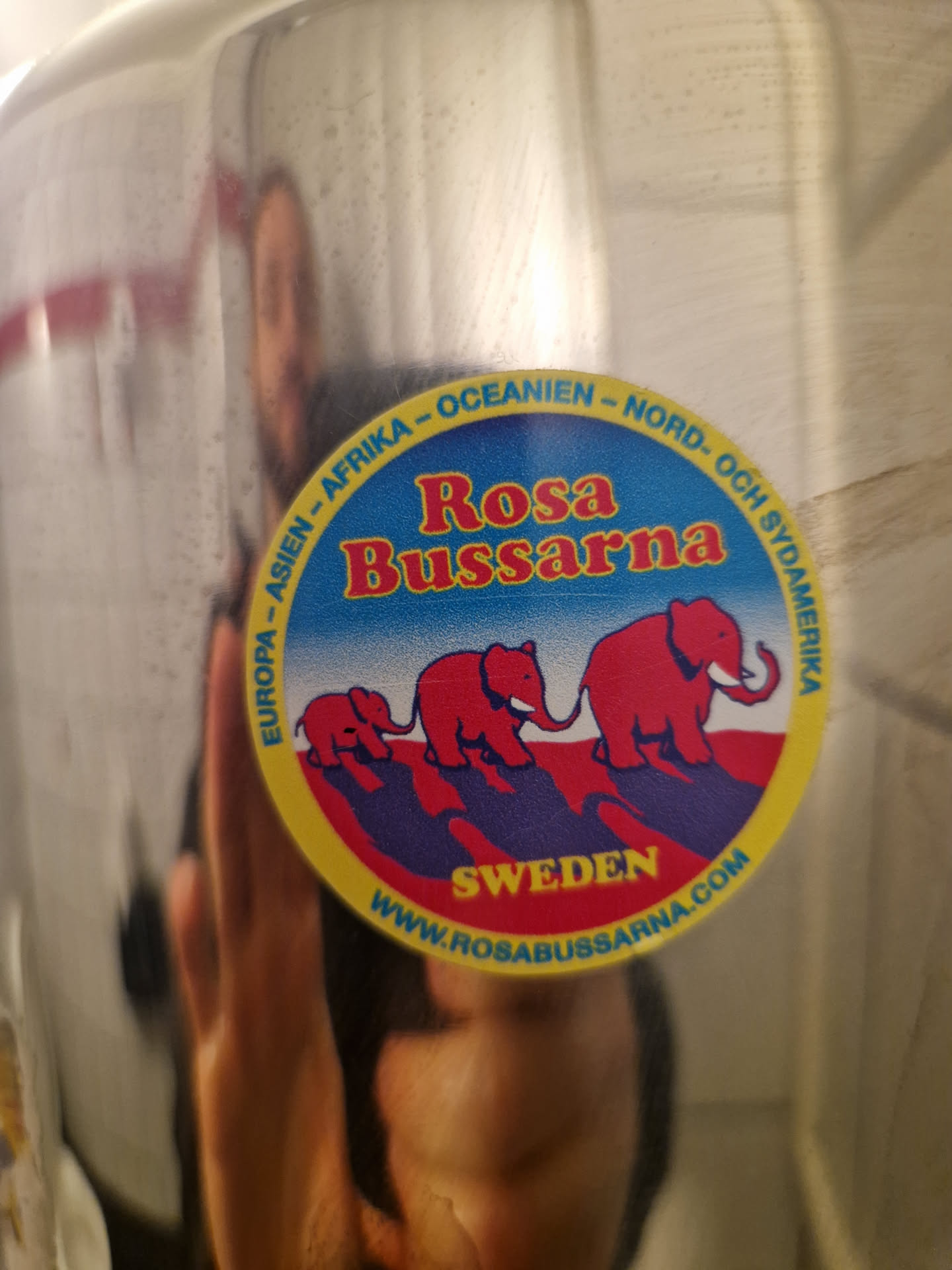 Round sticker featuring elephants and text. The text mentions Rosa Bussarna, Sweden, and the continents. A website address is included at the bottom of the sticker.