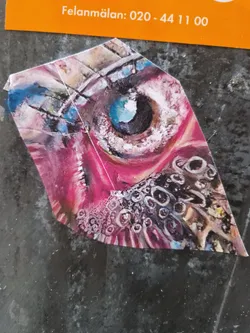 A unique sticker featuring a stylized eye with a mix of pink, blue, and gray tones.  The eye is surrounded by patterns that resemble scales or cells. The overall style is expressive and slightly surreal.