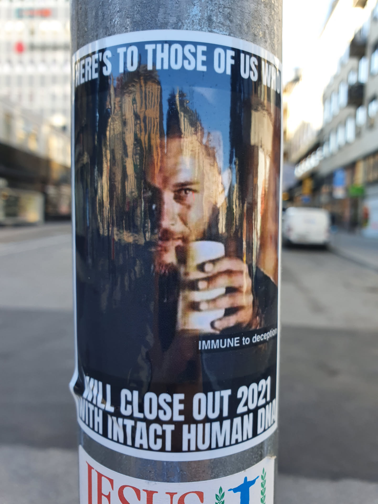 A sticker featuring a stylized image of a man, possibly Tom Hardy, holding a cup. The text on the sticker suggests a celebratory or defiant tone toward closing out the year 2021.  The style is reminiscent of internet memes.
