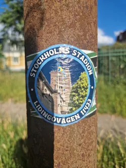 Round sticker featuring an image of Stockholm Stadion and text indicating its location on Lidingövägen 11433.