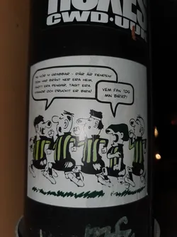 A sticker featuring a cartoon of a group of men in striped shirts, with speech bubbles containing Swedish text. The text roughly translates to: "Now lads - there's the enemy! They burned down your houses, stole your money, took your girls and drank your beer! Who the hell took my beer?!"