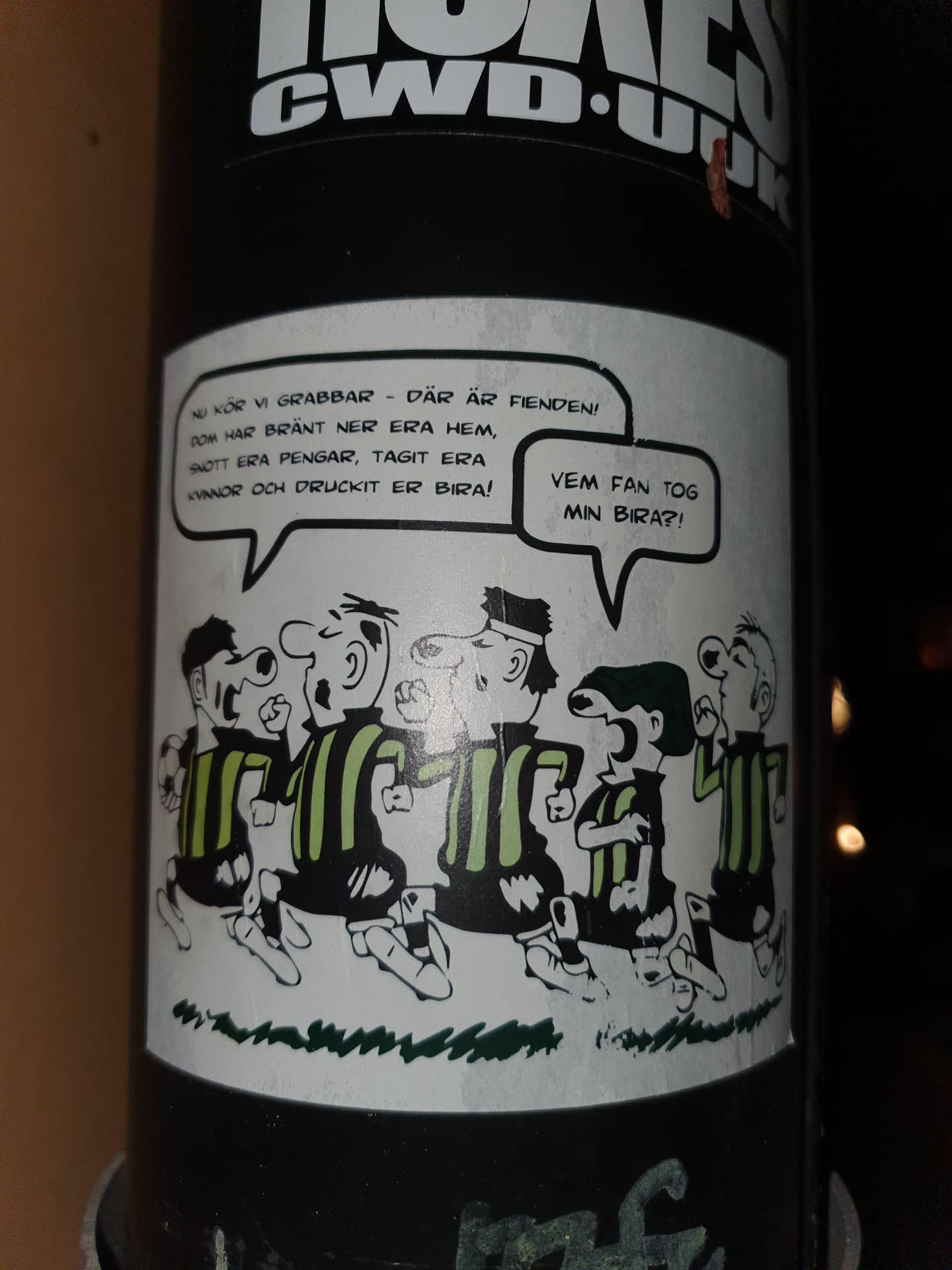 A sticker featuring a cartoon of a group of men in striped shirts, with speech bubbles containing Swedish text. The text roughly translates to: "Now lads - there's the enemy! They burned down your houses, stole your money, took your girls and drank your beer! Who the hell took my beer?!"