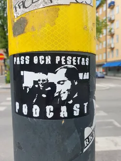 Black and white sticker featuring two men's faces and the text "Pass och Pesetas Podcast".