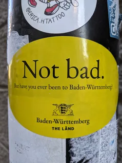 Yellow sticker promoting tourism in Baden-Württemberg, Germany. It features the state's coat of arms and tagline.