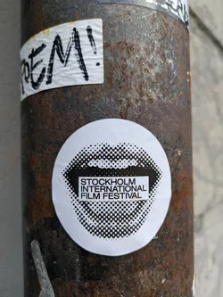 A round sticker with a halftone design of a mouth. The text 'STOCKHOLM INTERNATIONAL FILM FESTIVAL' is in a rectangular box in the center of the design.