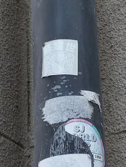 The sticker shows Chinese characters at the top, possibly indicating a name or place.  Below, there is an emblem resembling a crest, featuring what looks like a staircase within a shield.  The style is minimalist and simple, using only white ink on a transparent background.  The sticker is affixed to a dark gray pipe.