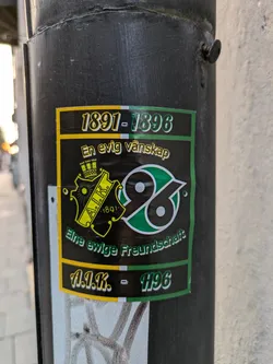 A sticker commemorating the friendship between AIK and Hannover 96, established in 1891. The sticker features the logos of both clubs and text in Swedish and German.
