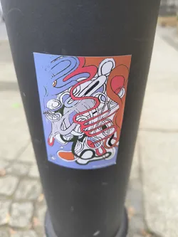 An abstract sticker featuring squiggly lines and shapes in red, orange, and blue tones is adhered to a black metal pole. The composition has a whimsical and fluid quality, with the overlapping lines creating a dynamic visual texture.