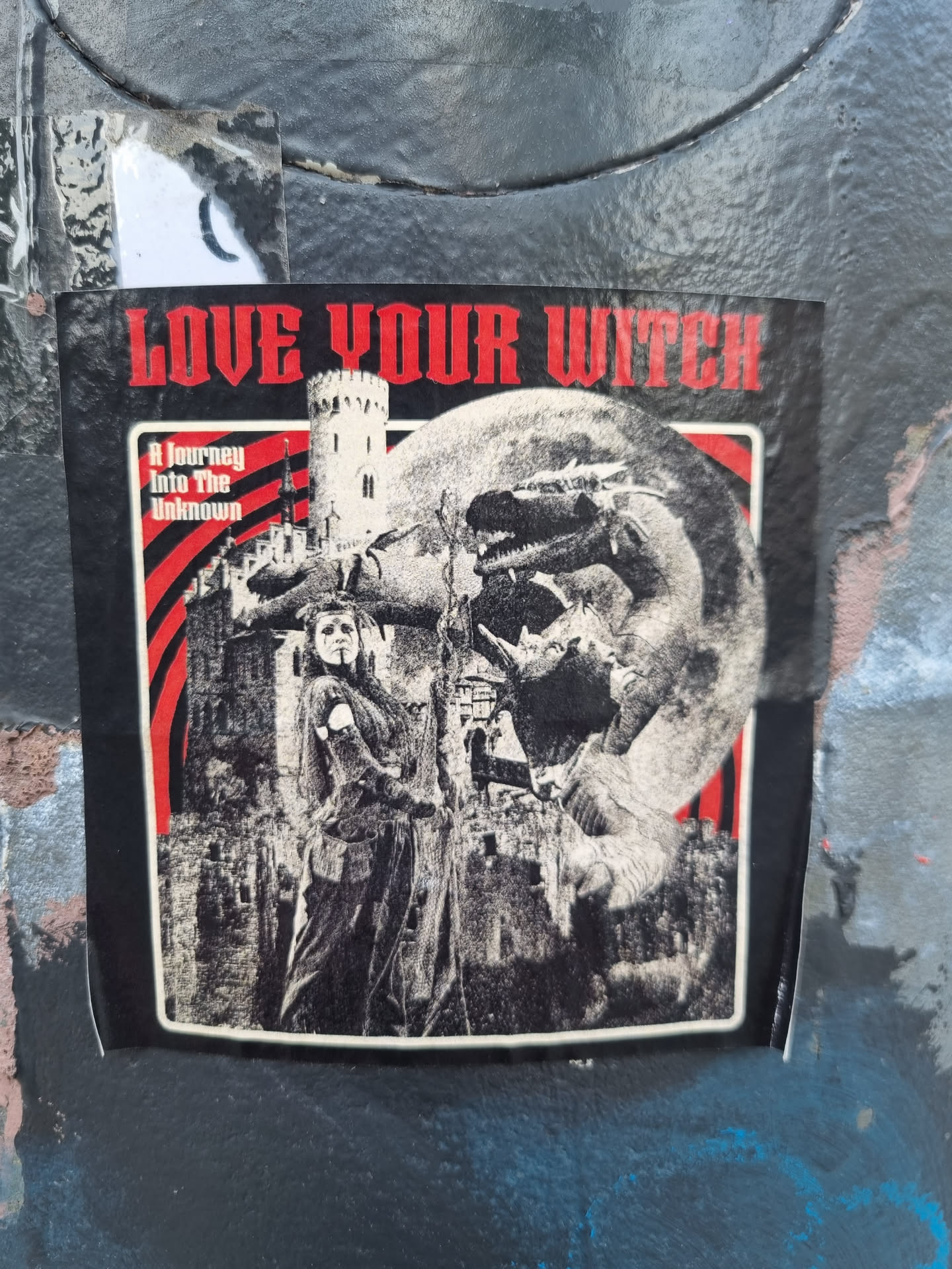 A sticker featuring a dark fantasy illustration of a witch, a dragon, and a castle. The text 'Love Your Witch' is prominently displayed at the top, with 'A Journey Into The Unknown' written underneath. The style is reminiscent of vintage occult or gothic art.