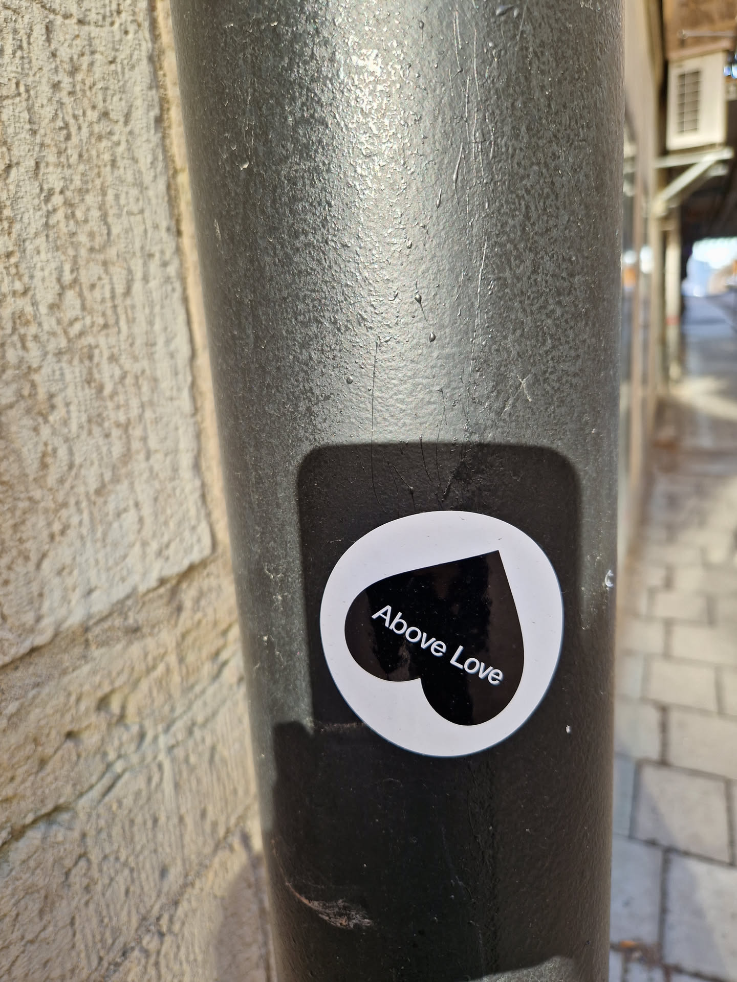 A black and white sticker with a heart shape and the text 'Above Love'.