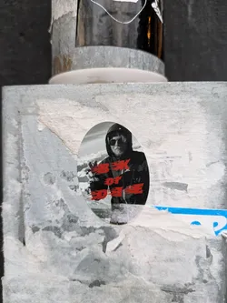 Oval sticker featuring a black and white image of a man wearing a hooded jacket and sunglasses. Red text on the sticker says "Box of DEEE".
