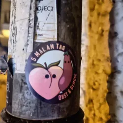 A round sticker featuring a peach and an eggplant with cute faces. The text on the sticker says "5 Mal am Tag Obst & Gemüse" which translates to "5 times a day fruit & vegetables".