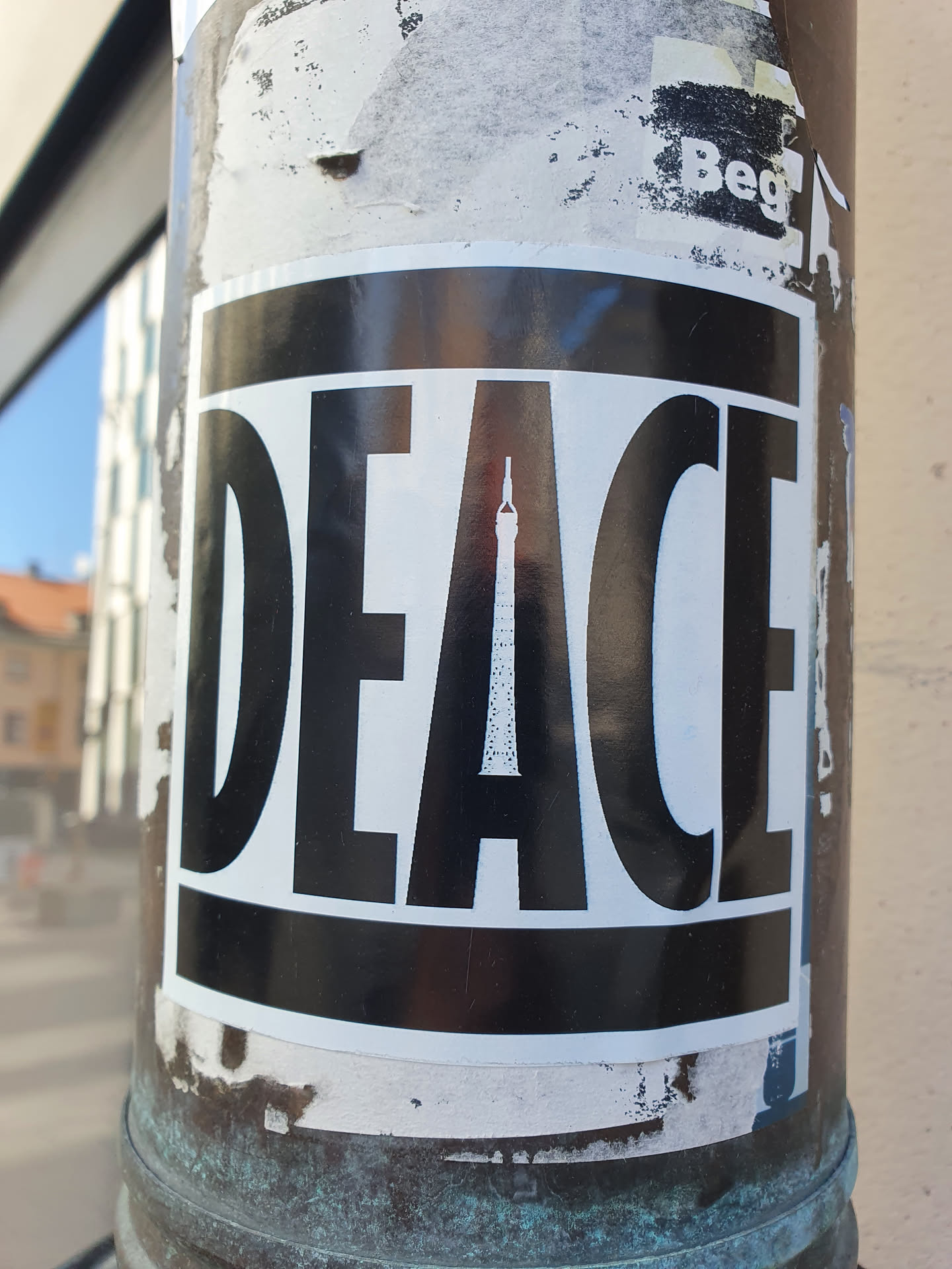Black and white sticker with the word PEACE. A tower is visible in the center of the letters.