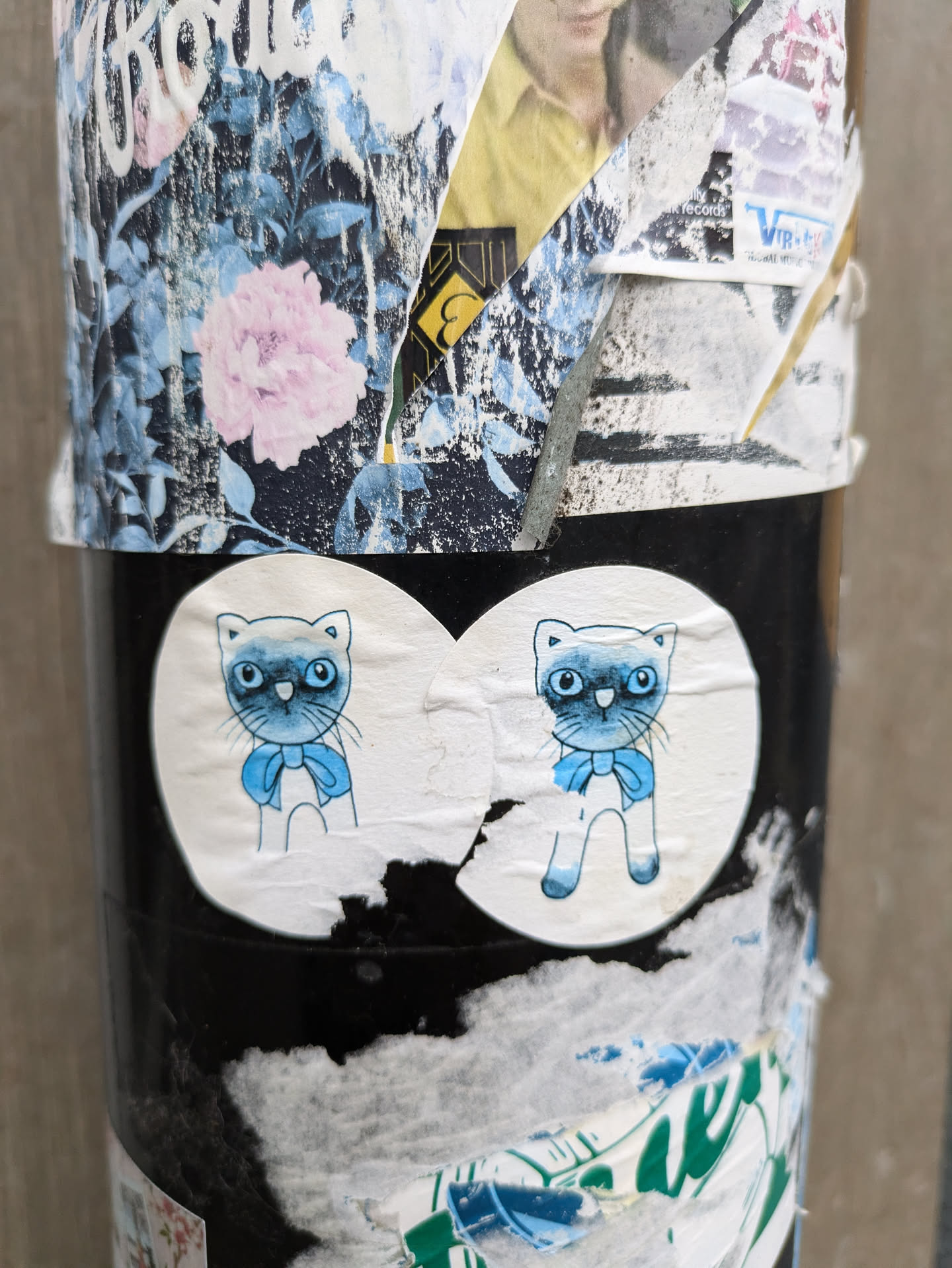 A sticker featuring two adorable cartoon cats wearing blue bows.  The cats are light blue/grey with darker blue eyes and are depicted in a simple, charming style.
