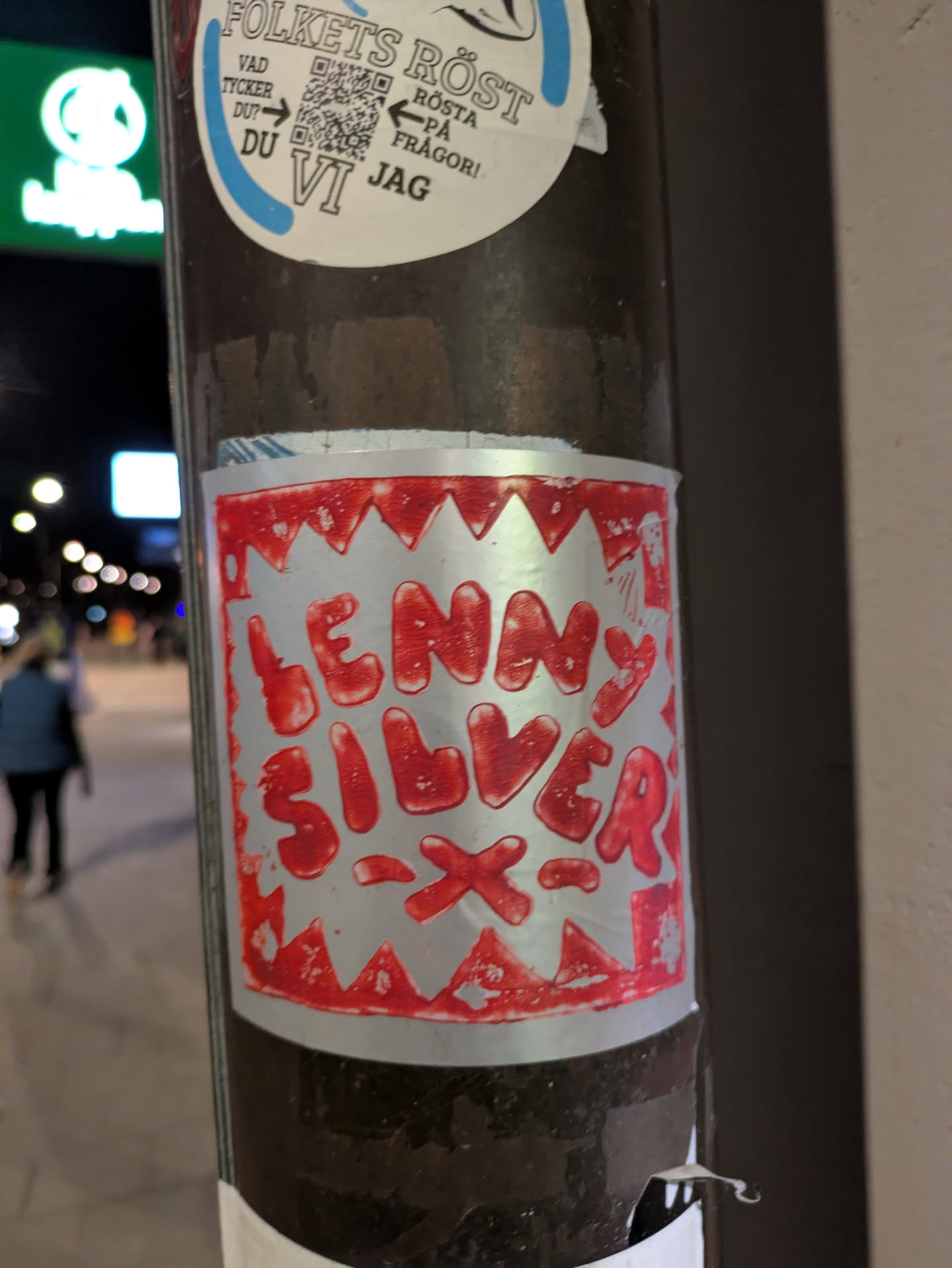This sticker features the text 'LENNY SILVER' in a stylized, somewhat dripping red font on a metallic silver background. The sticker's border is decorated with a sawtooth pattern, also in red. The overall look is reminiscent of hand-drawn or stencil art.