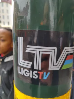 A black sticker with a stylized logo of LigisTV in white and colored stripes. The text 'LigisTV' is written beneath the logo.