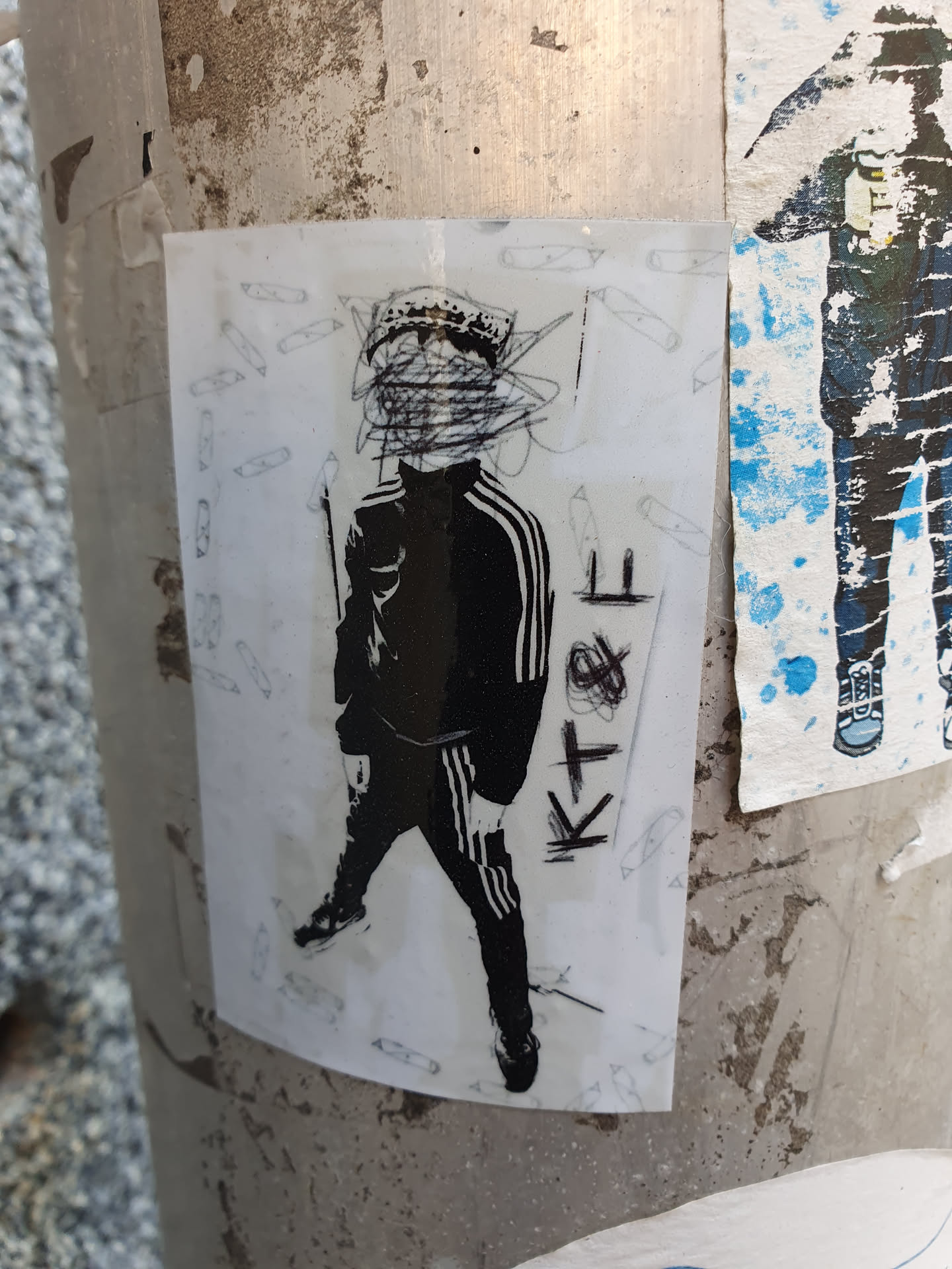 The sticker features a stylized black and white illustration of a person. Their face is obscured by a chaotic mass of lines, while the rest of their body is visible, suggesting they're wearing adidas track pants. The style is reminiscent of street art or graffiti.