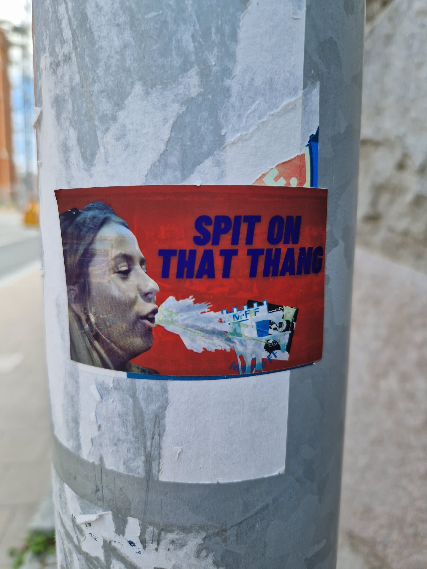 A sticker featuring a woman spitting, with the text "Spit on that thang" in bold blue letters on a red background.  The style is provocative and slightly edgy.