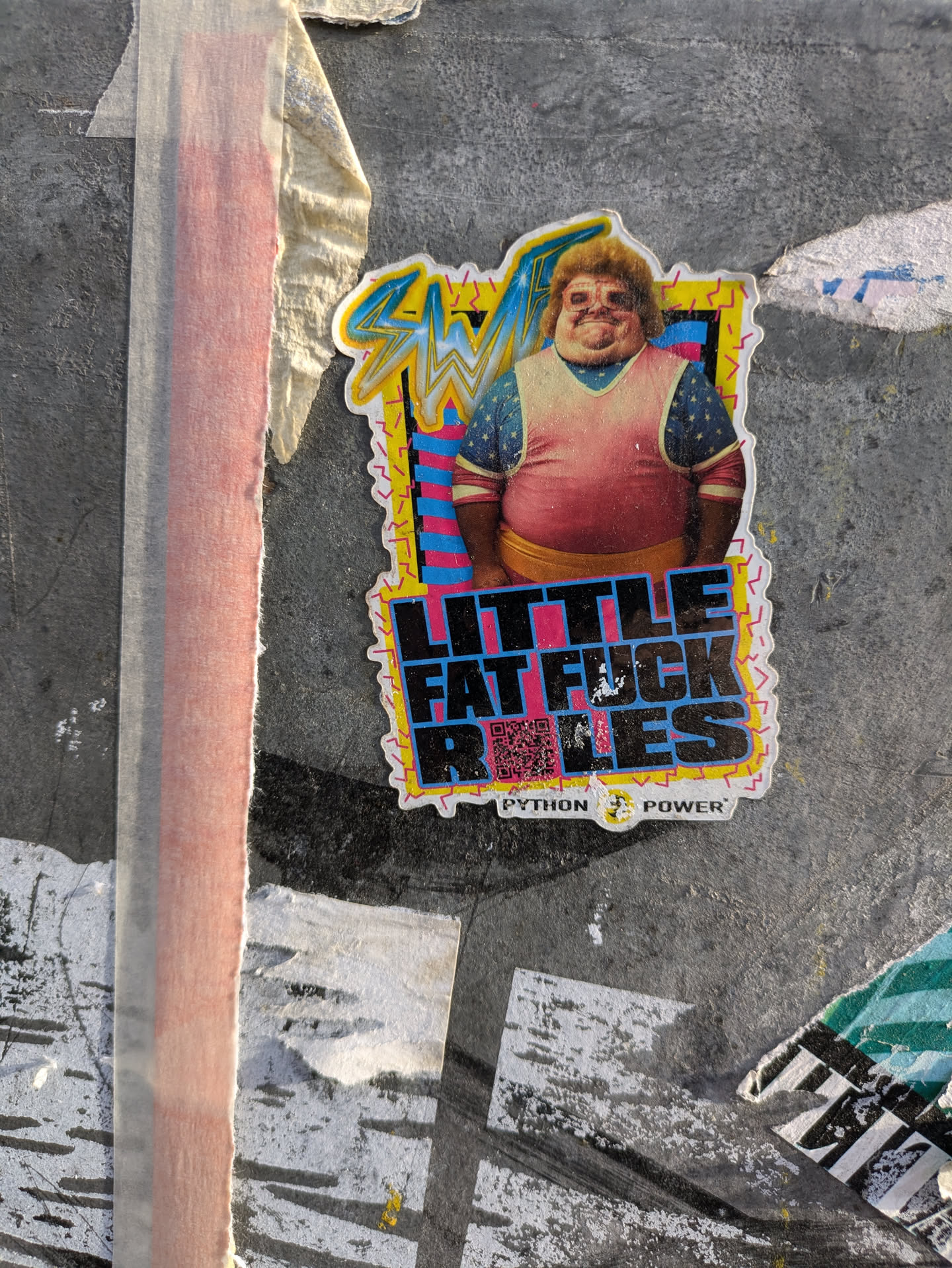 A sticker featuring a cartoon of an overweight man in 80s workout attire with the text "Little Fat Fuck Rules" underneath.  The sticker also includes stylized text at the top and "PYTHON POWER" at the bottom.