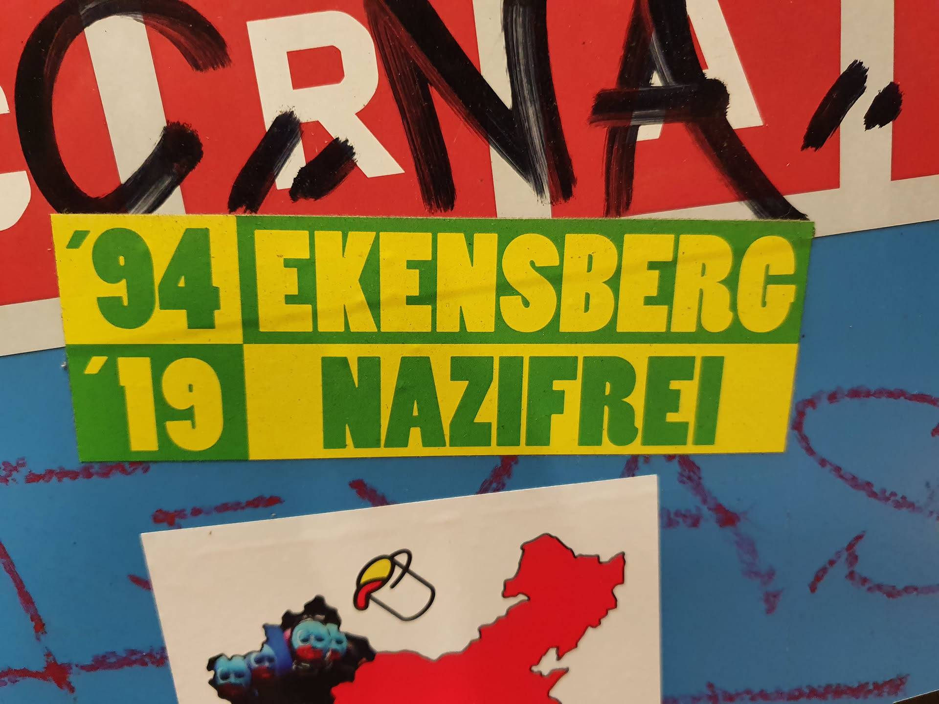 A sticker with the text '94 Ekensberg '19 Nazifrei'.  The sticker is yellow and green. The text is in a bold, sans-serif font.