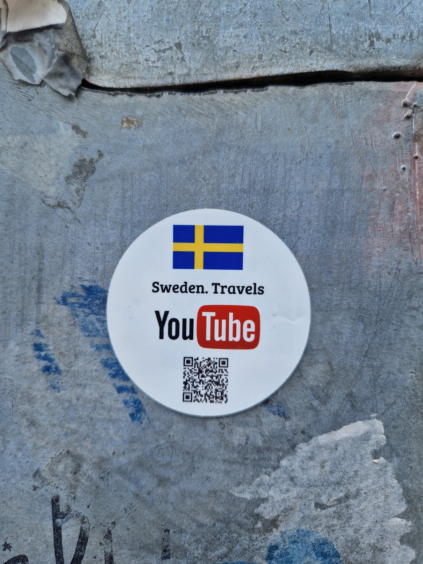 Round white sticker with the flag of Sweden, the YouTube logo, and a QR code.  The text 'Sweden. Travels' is also present.