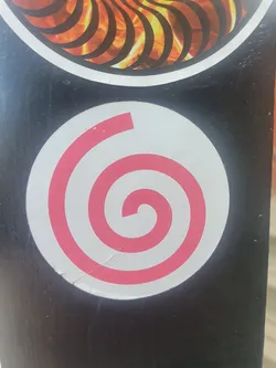 A round sticker with a pink spiral on a white background. The sticker is slightly damaged.