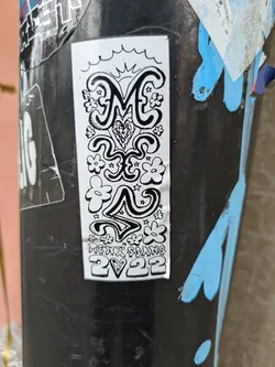 A black and white sticker featuring stylized lettering of 'ME', surrounded by flowers, stars, and a heart. The text 'Hexx Sams 2♡22' is present at the bottom. The style is reminiscent of 70s psychedelic art.