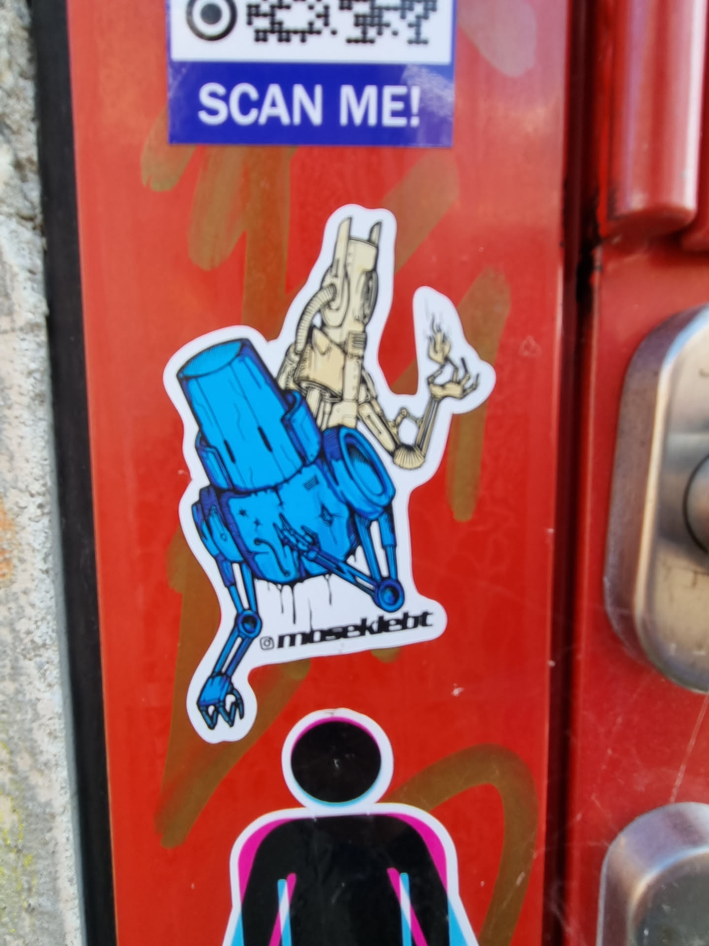 A sticker featuring a robot design in blue and beige colors. The robot appears to be sitting on a blue cylindrical object, with mechanical legs and arms. The style is cartoonish and slightly rough around the edges, suggesting a hand-drawn aesthetic. An artist's tag '@mosekdebt' is visible in the bottom right corner of the sticker.