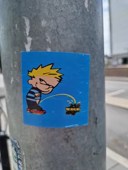 A sticker featuring Calvin from the comic strip Calvin and Hobbes, in a playful act of urinating on a logo that says "AIR". The sticker has a blue background and a cartoonish style.