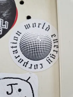 A round sticker with a black and white design. It features a disco ball graphic in the center, surrounded by text that reads "World revolution energy" in a stylized, gothic-style font.