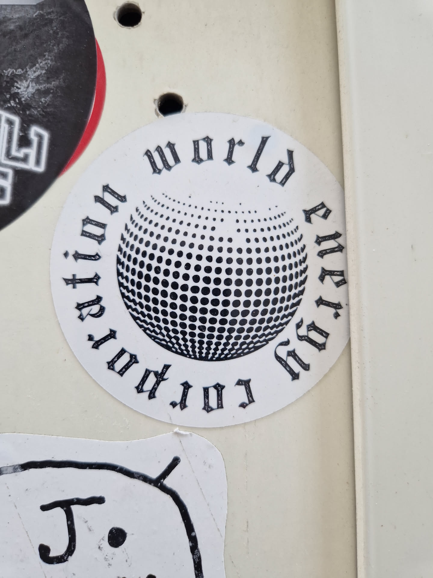 A round sticker with a black and white design. It features a disco ball graphic in the center, surrounded by text that reads "World revolution energy" in a stylized, gothic-style font.