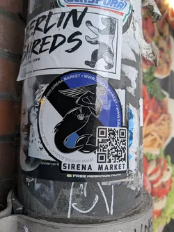 Street sticker A circular vinyl sticker with an attached rectangular extension at the bottom right. The central artwork displays a stylized black and white illustration of a mermaid with flowing hair and a seashell detail against a split background of cobalt blue and light gray/white. Surrounding the perimeter of the circular section is the repeating web address 'WWW.SIRENA.MARKET'. The lower-right corner features a prominent black-and-white QR code positioned above the label 'SIRENA MARKET' printed in bold, sans-serif uppercase letters.