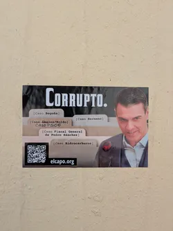 The sticker features the word "CORRUPTO" (corrupt) in large letters, accompanied by a photo of a man and various file folder labels such as "Caso Begoña" and "Caso Hidrocarburos". It also includes a QR code and the web address elcapo.org.