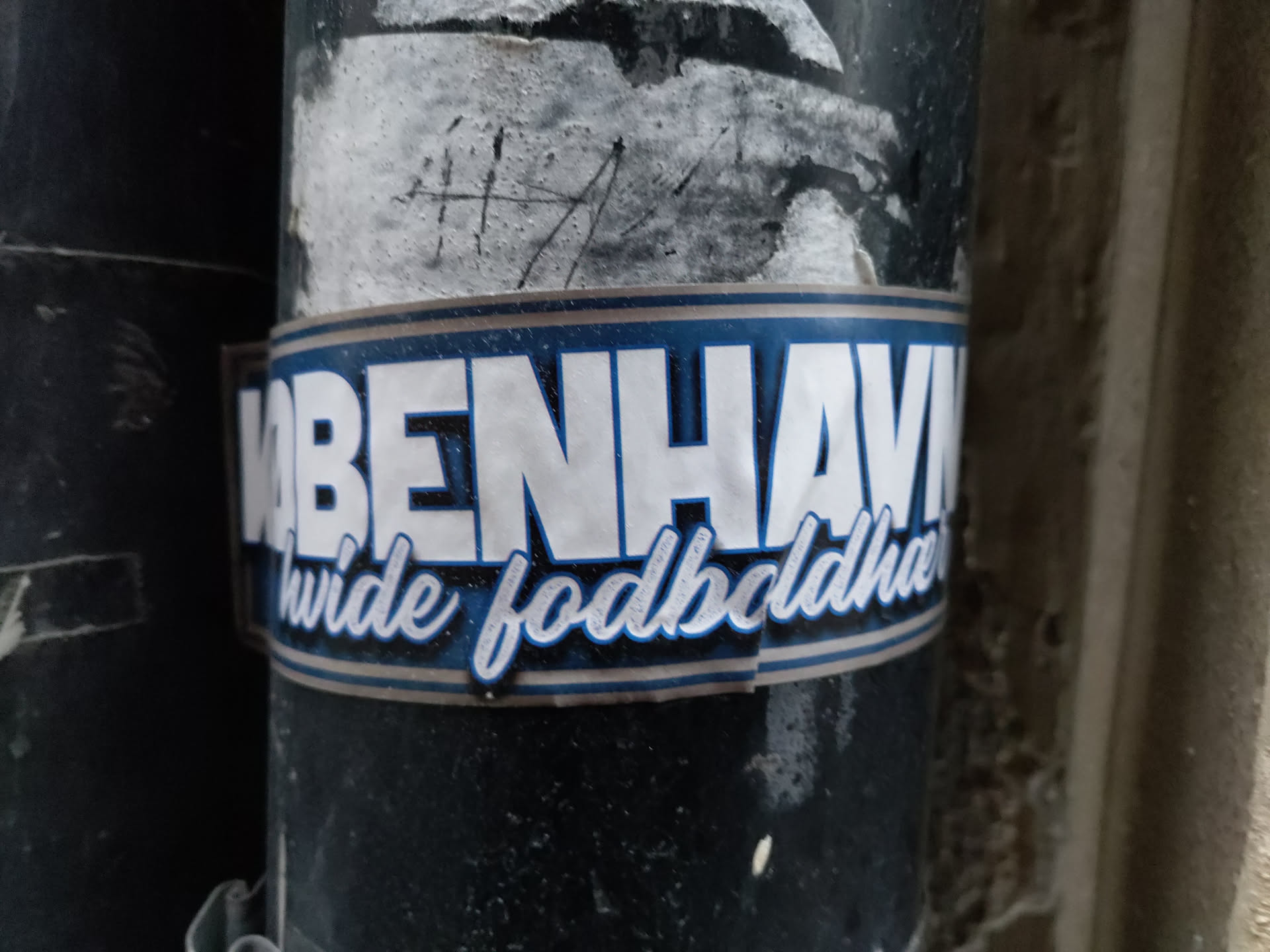 A sticker featuring the text "KØBENHAVN hvide fodboldhuer" in white lettering on a dark blue background. The text is stylized with a bold font and a curved script for the words "hvide fodboldhuer".
