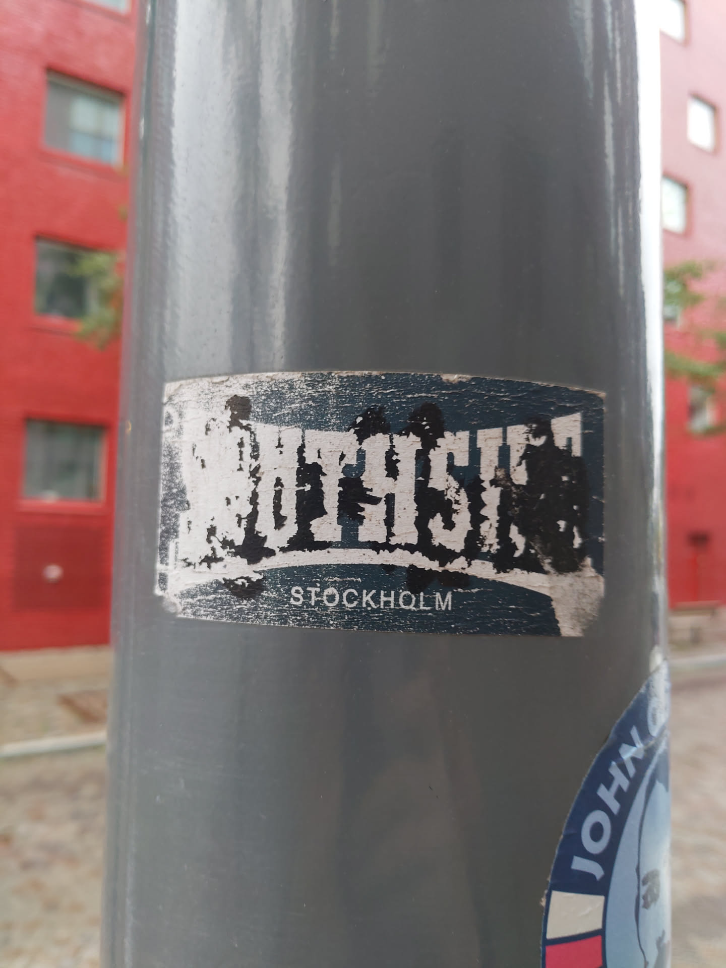 A sticker featuring the text SOUTH SIDE STOCKHOLM. The sticker has a worn look, suggesting it has been affixed to a surface for some time. 